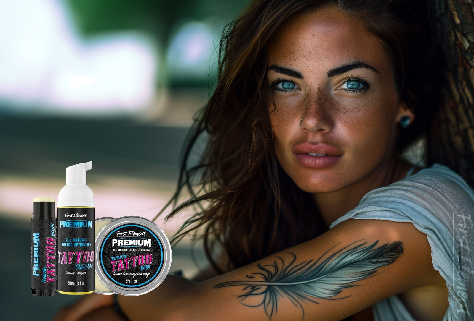 Woman with feather tattoo and blue eyes sitting outdoors, showcasing First Element tattoo aftercare products