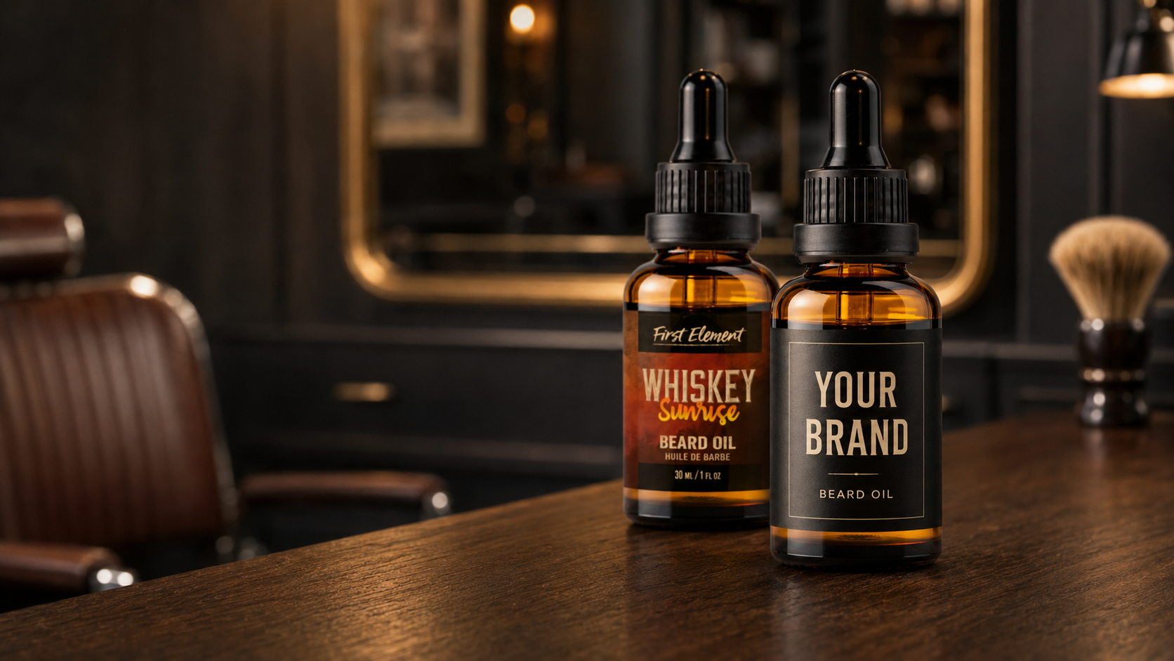 Two amber glass dropper bottles of beard oil standing on a dark wooden counter in a barbershop setting. The bottle on the left has a label reading 'First Element' and 'Whiskey Smoothie Beard Oil', while the bottle on the right has a custom placeholder label reading 'YOUR BRAND' and 'BEARD OIL'.