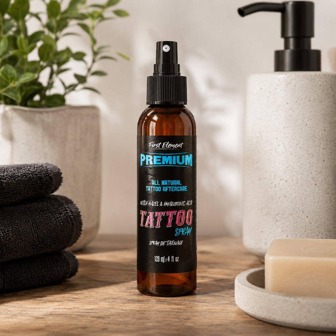 Bottle of tattoo aftercare spray on a wooden surface with towels and a plant in the background