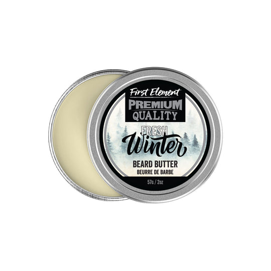 A 2oz metal tin of Fresh Winter Beard Butter with a screw-on lid and tamper-evident seal. The tin is placed on a white surface with soft lighting, showcasing its premium quality. Text on the label reads 'Fresh Winter Beard Butter: Handcrafted in Canada for soft, moisturized beards and skin. Contains Grapefruit Pink, Peppermint, and Rosemary essential oils.